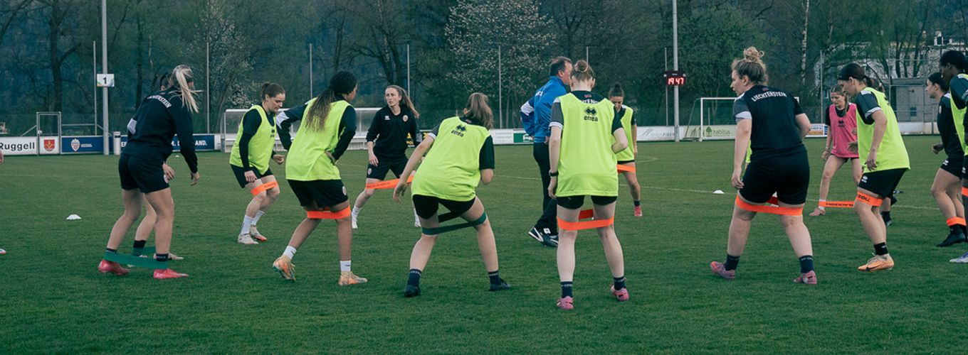 Das Foto zeigt das Team bei Aufwärmübungen im Kreis.